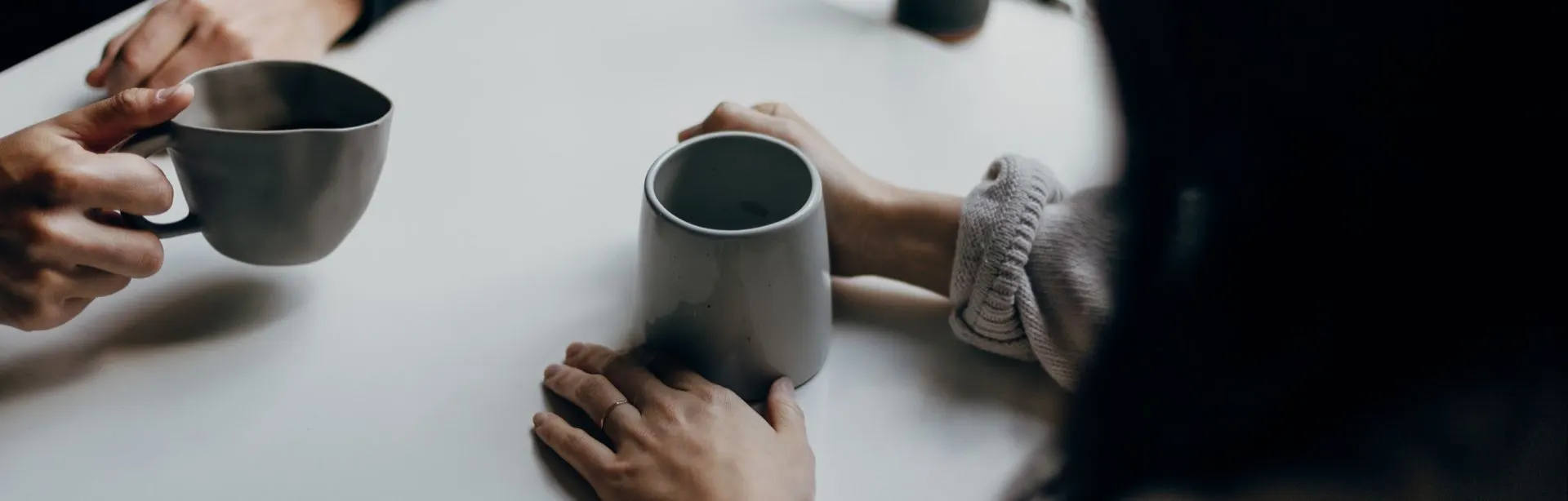 Two people talking over cups of coffee