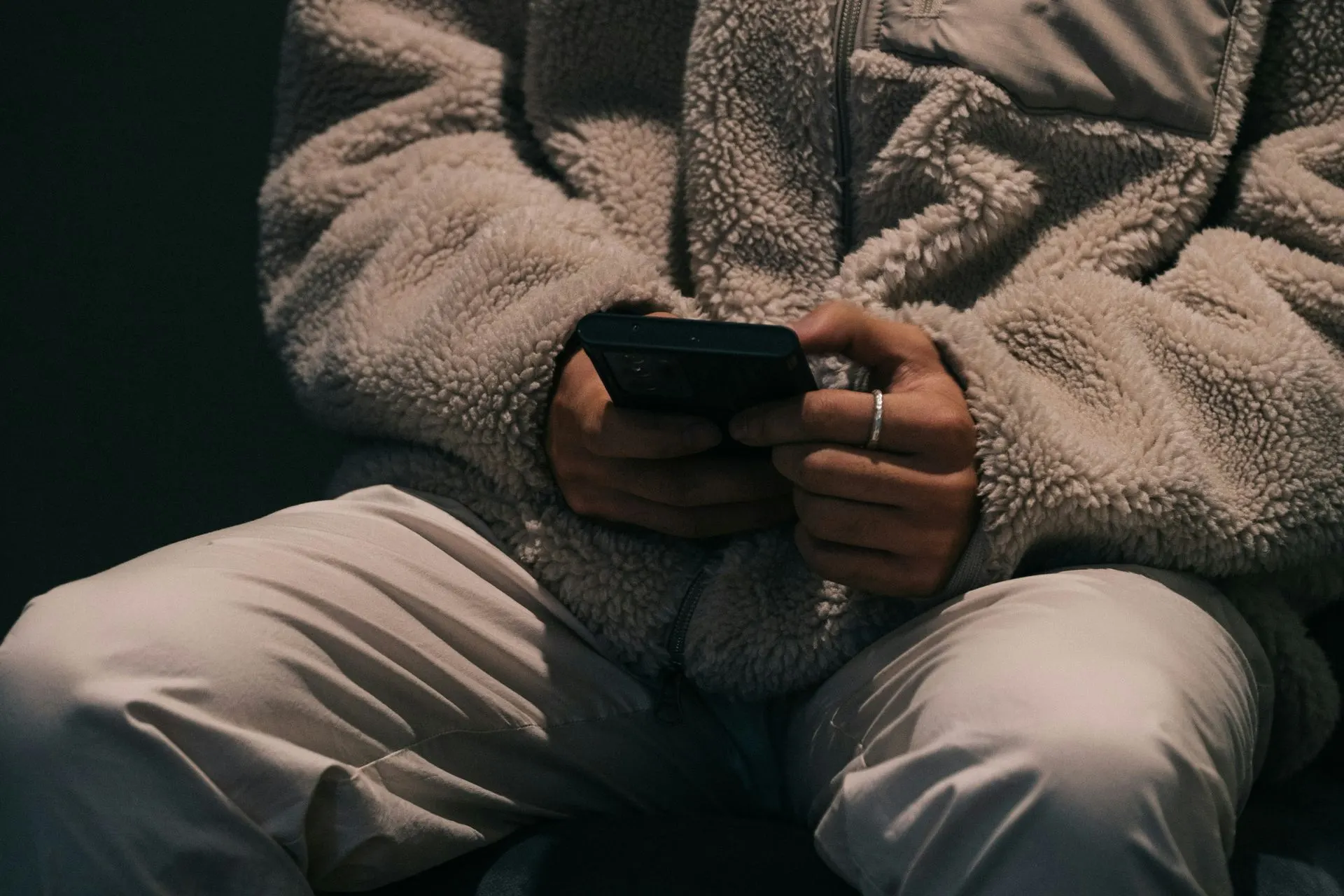 Person holding a phone in their lap