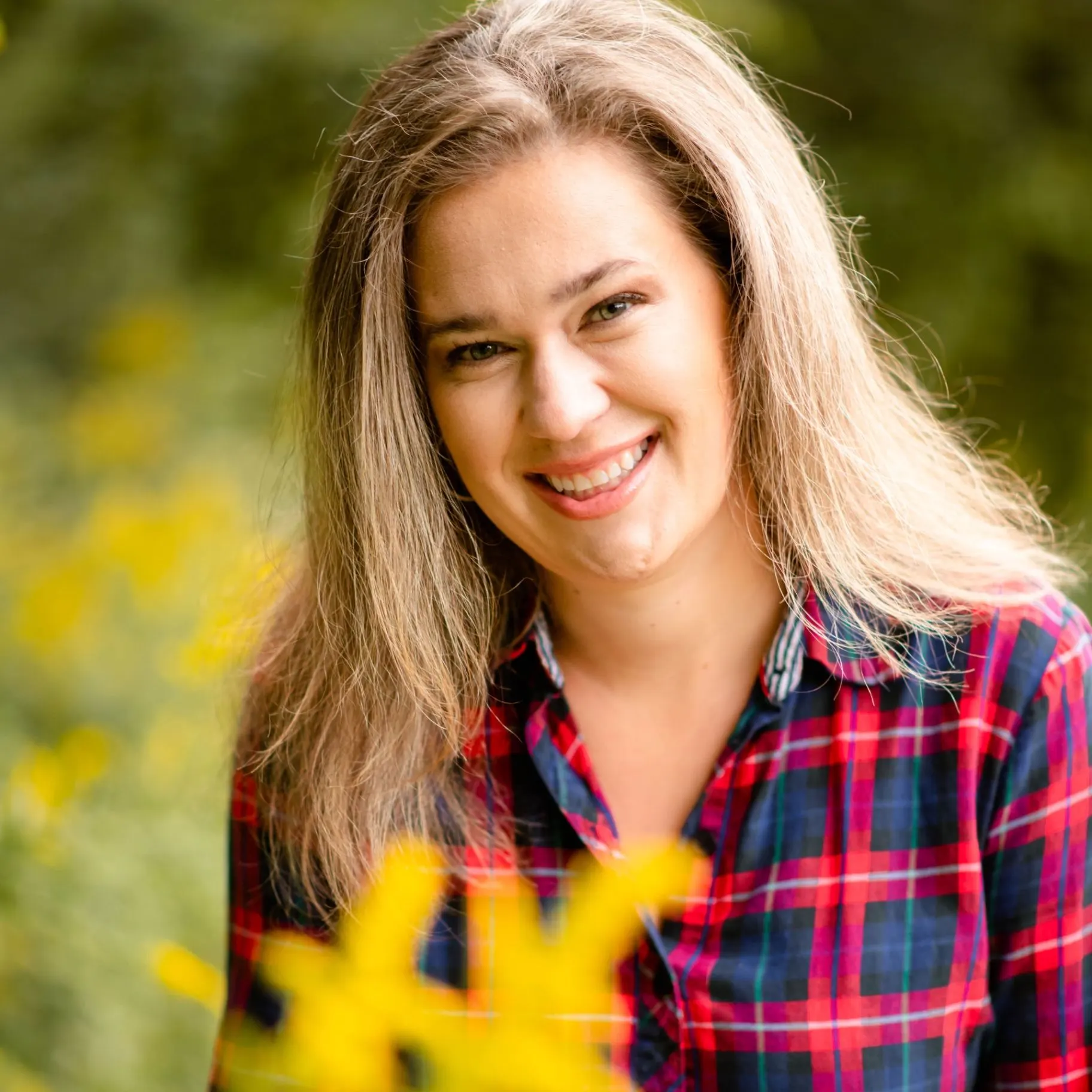 Samantha Sanders smiling among sunflowers