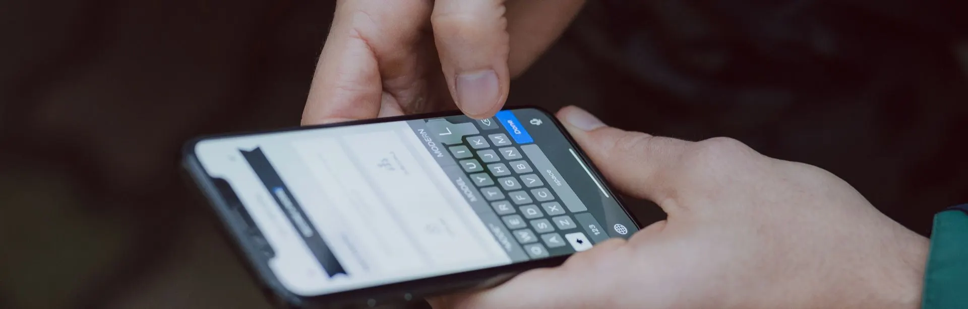Hands typing on a smartphone